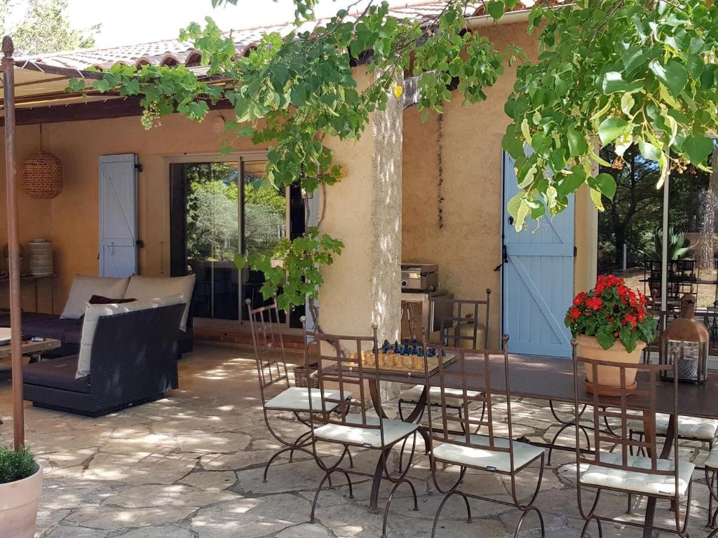 オプスにあるVery attractive detached villa with swimming poolの木の下にテーブルと椅子のあるパティオ