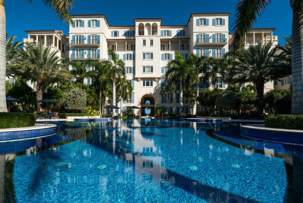 a swimming pool in front of a building at The Regent Grand in Grace Bay