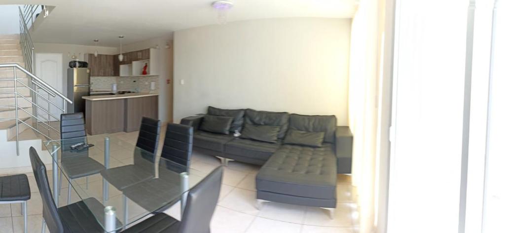 sala de estar con sofá y mesa de cristal en Apartamento duplex, con terraza y vista de Chiclayo, en Chiclayo