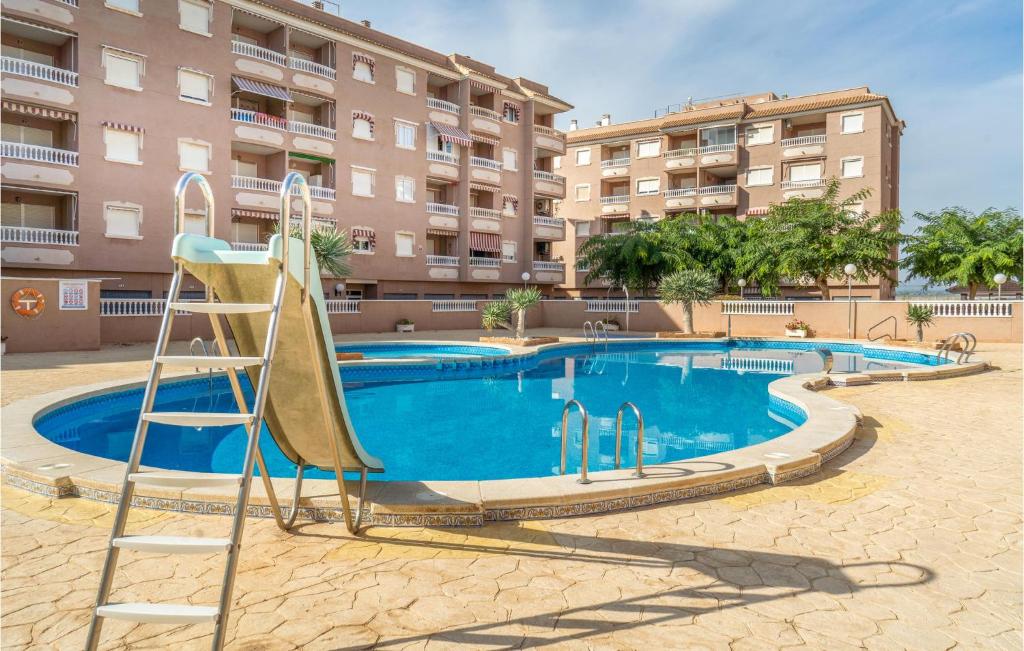 a swimming pool with a slide in front of a building at Amazing Apartment In Santa Pola in Santa Pola
