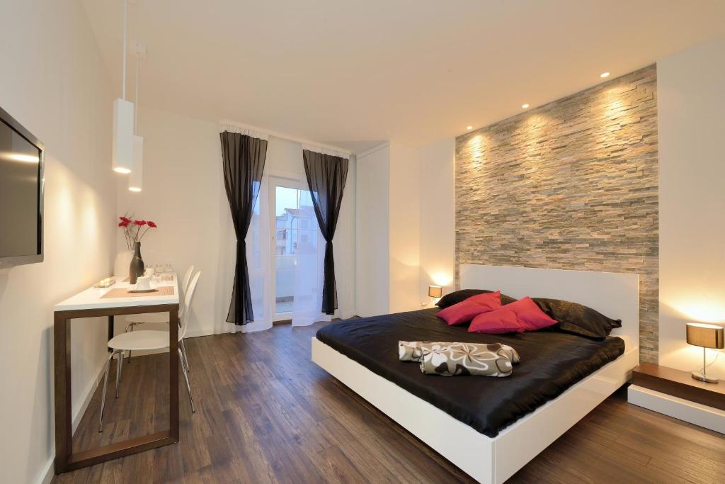 1 dormitorio con 1 cama grande, escritorio y mesa en Guest house D&G -I apartment & room, en Zadar
