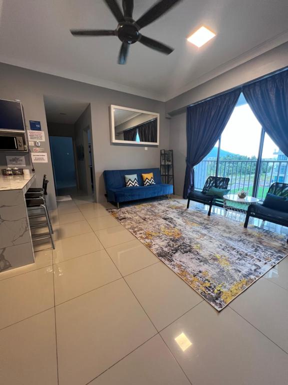 a living room with a blue couch and a large window at Casahome by Irdina Meru- 8pax -10pax in Ipoh