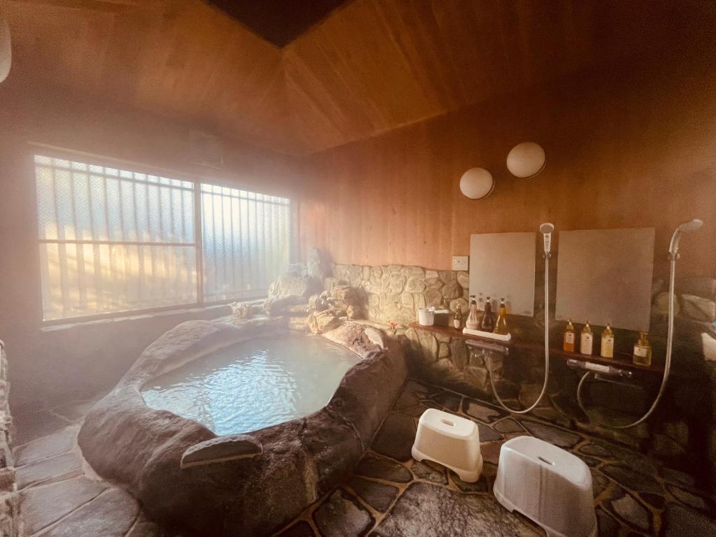 La salle de bains est pourvue d'une grande baignoire. dans l'établissement Secret Garden Resort&Onsen秘密の花園箱根温泉別荘, à Sengokuhara