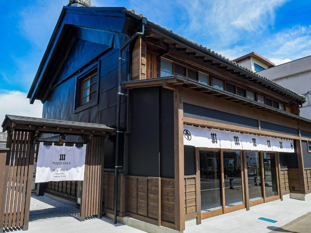 a black building with a blue roof and windows at NIPPONIA Chichibu Monzenmachi in Chichibu