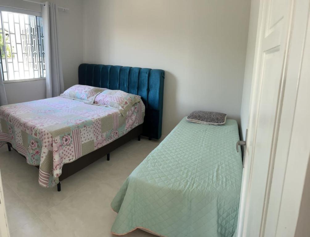 1 dormitorio con 1 cama, 1 cama pequeña y ventana en Casa da Penha/SC, en Penha