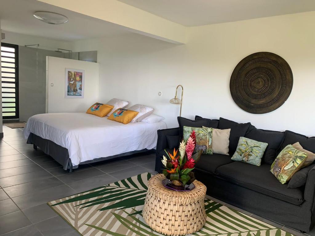a living room with a couch and a bed at STUDIO O'KALM in Le Gosier