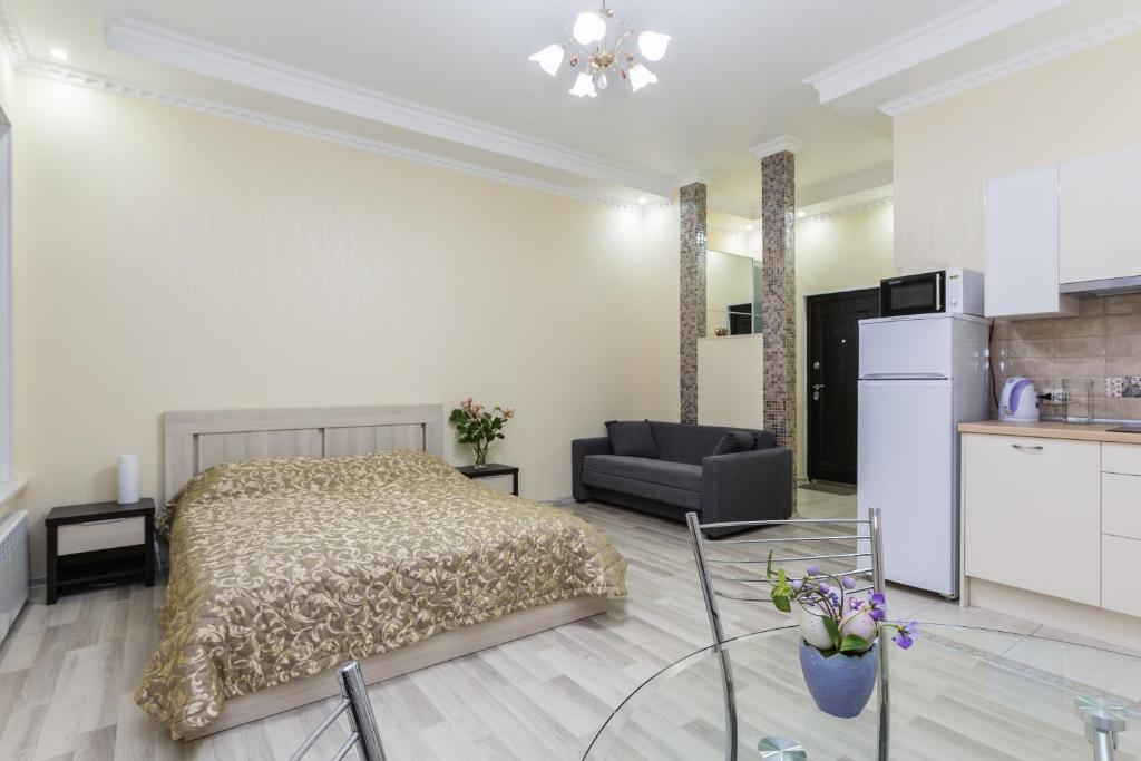 a bedroom with a bed and a living room at Na Konyushennom Apartments in Saint Petersburg