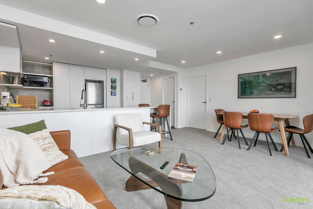 a living room with a couch and a table at QV Stays Upscale Modern Getaway in Auckland