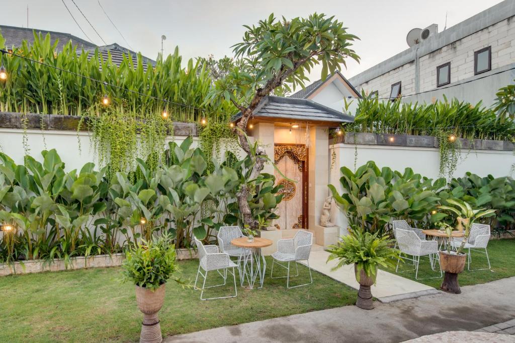 a backyard with a table and chairs and plants at Puspa Ayu Villas & Apartments in Kuta