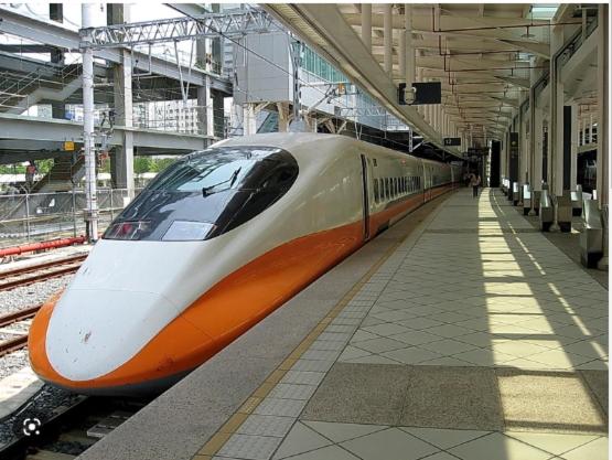 a white and orange train at a train station at Long Siang Hotel in Kaohsiung