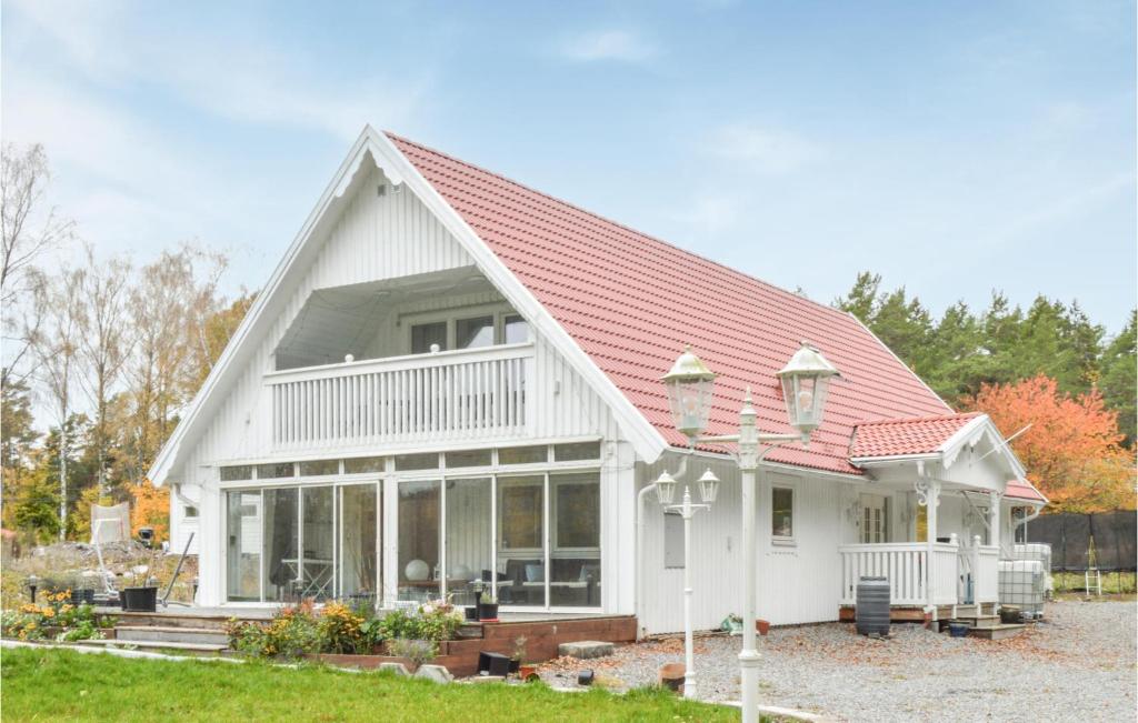 ein weißes Haus mit rotem Dach in der Unterkunft Awesome Home In Djurhamn With Kitchen in Djurhamn