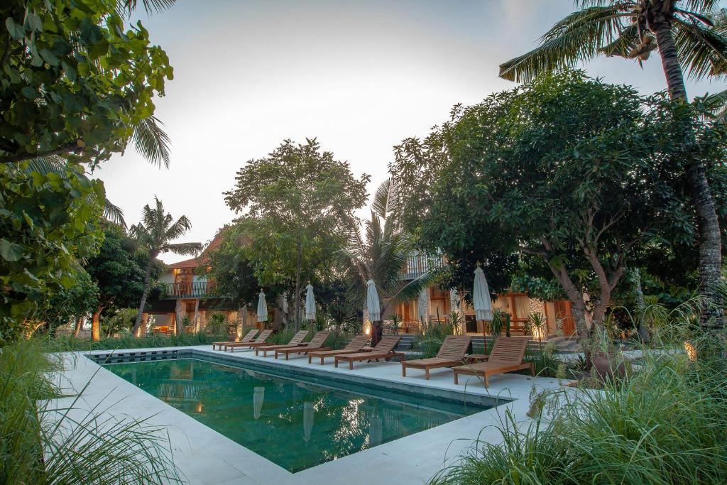 a swimming pool with lounge chairs and a resort at Diamond Beach Villas in Nusa Penida