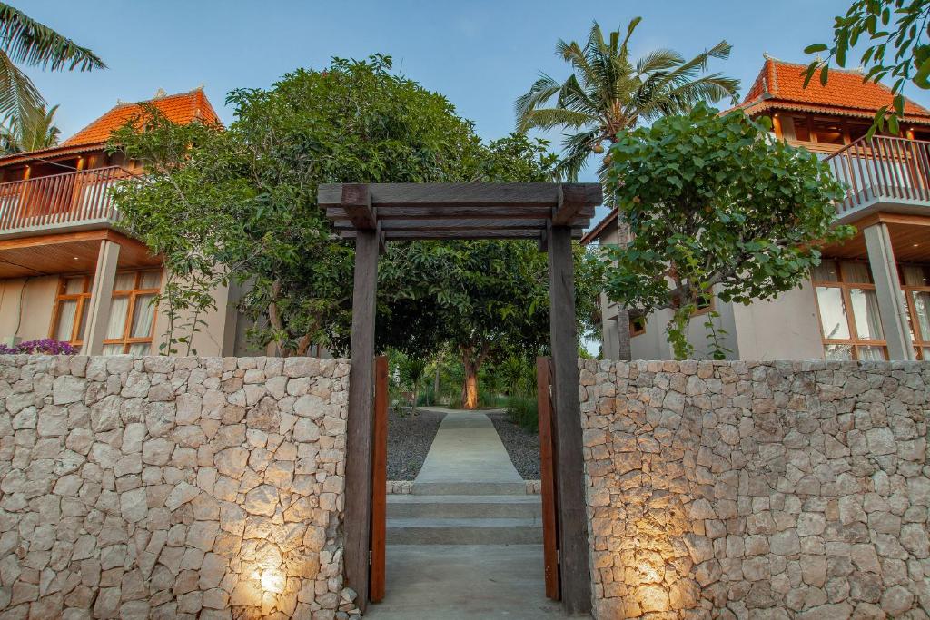 an entrance to a building with a stone fence at Diamond Beach Villas in Nusa Penida