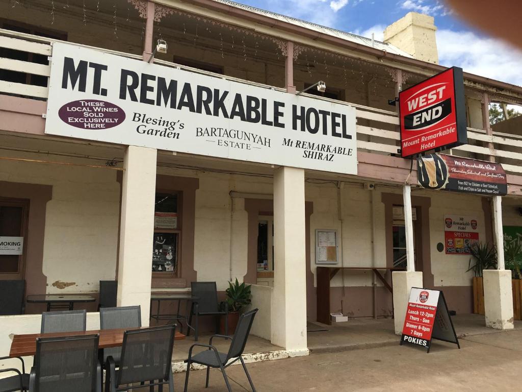 a mr reaganizable hotel with tables and chairs in front at Mt. Remarkable Hotel Motel in Melrose