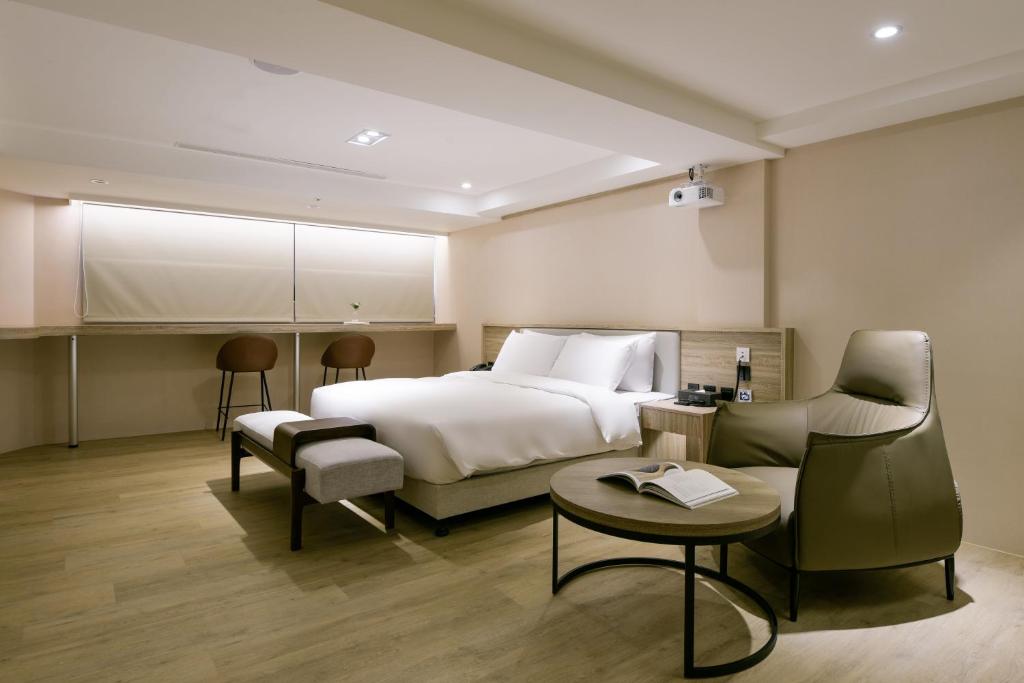 a hotel room with a bed and a couch at Spring Rhapsody Hotel in Taichung