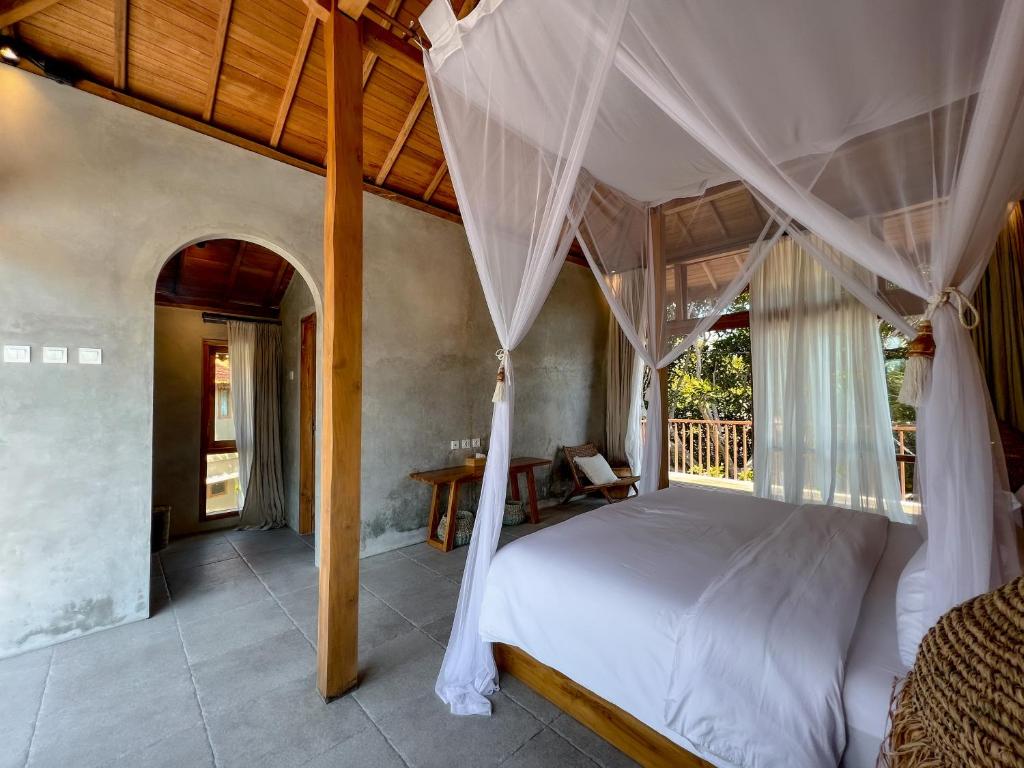a bedroom with a large bed with a canopy at Diamond Beach Villas in Nusa Penida