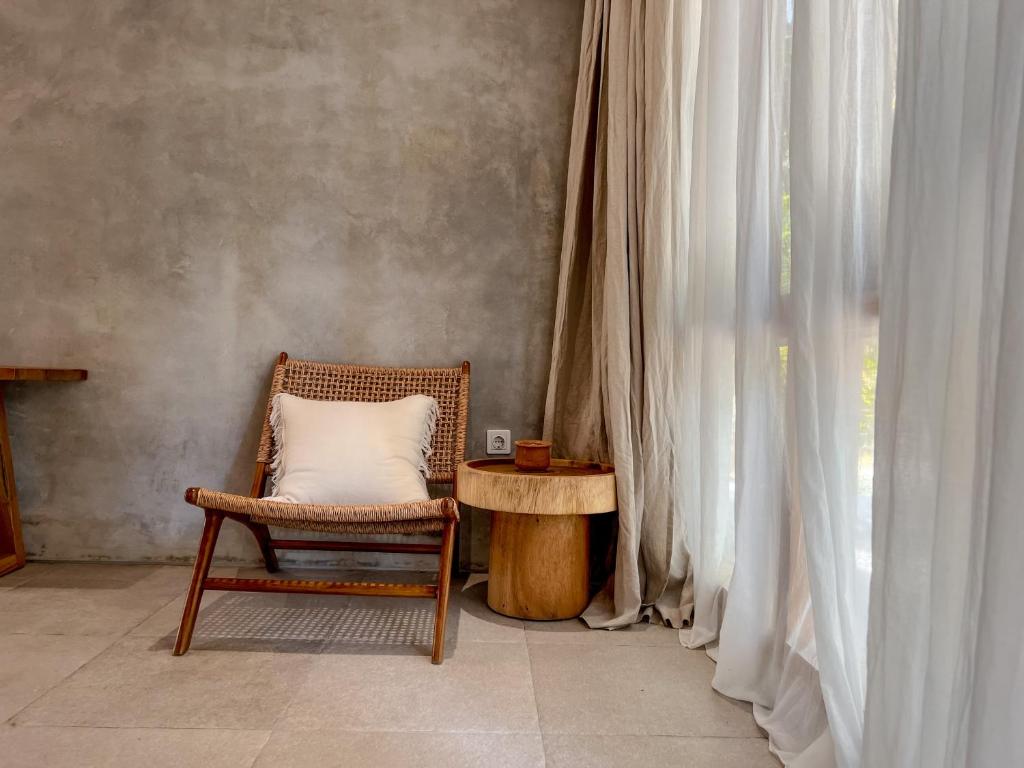 a chair with a pillow sitting next to a window at Diamond Beach Villas in Nusa Penida
