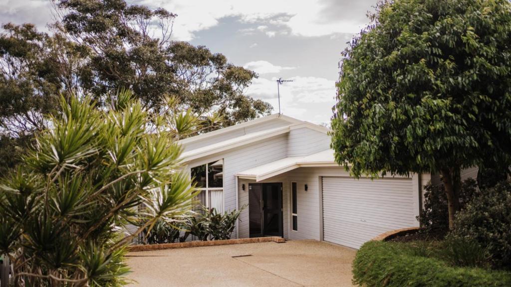 a white house with a garage at Standing Stones Shelly Beach in Port Macquarie