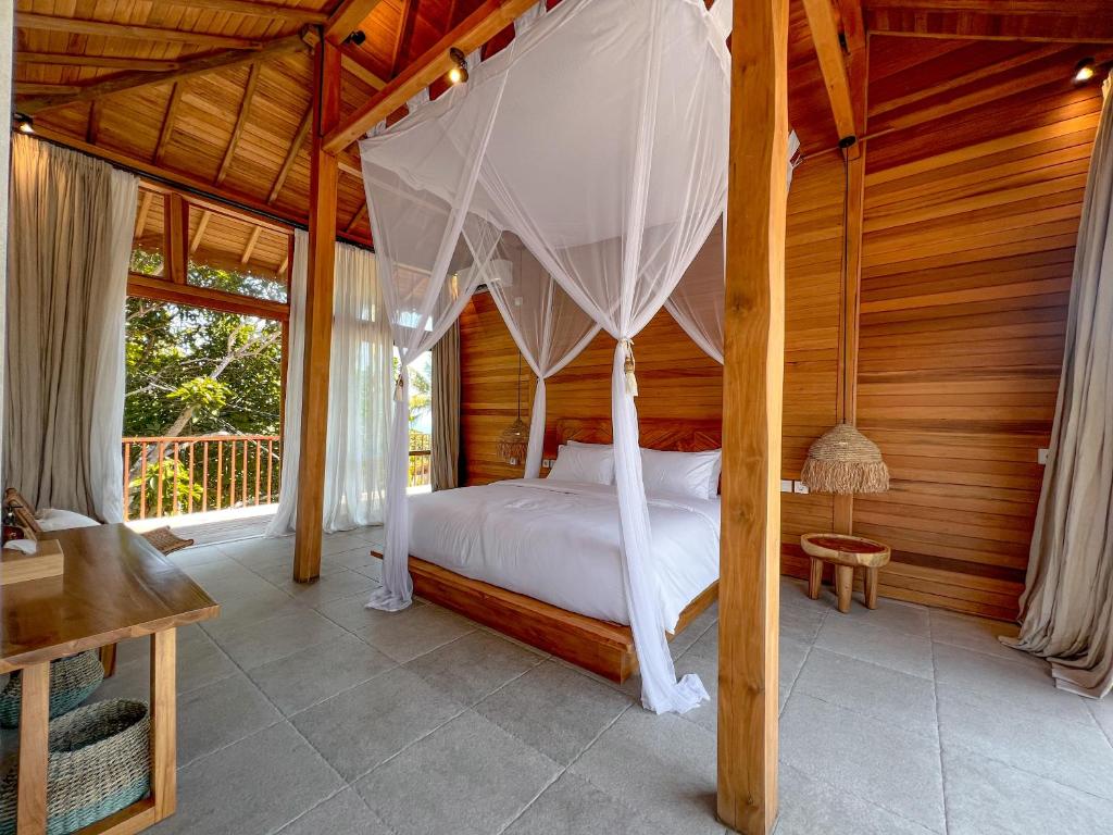 a bedroom with a canopy bed in a house at Diamond Beach Villas in Nusa Penida