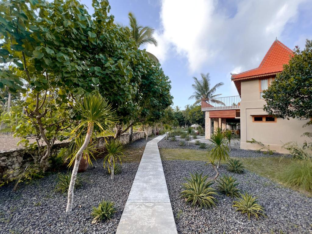 a walkway in front of a house with trees at Diamond Beach Villas in Nusa Penida