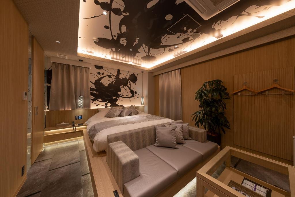 1 dormitorio con cama y sofá en HOTELみなと-MINATO-, en Tokio