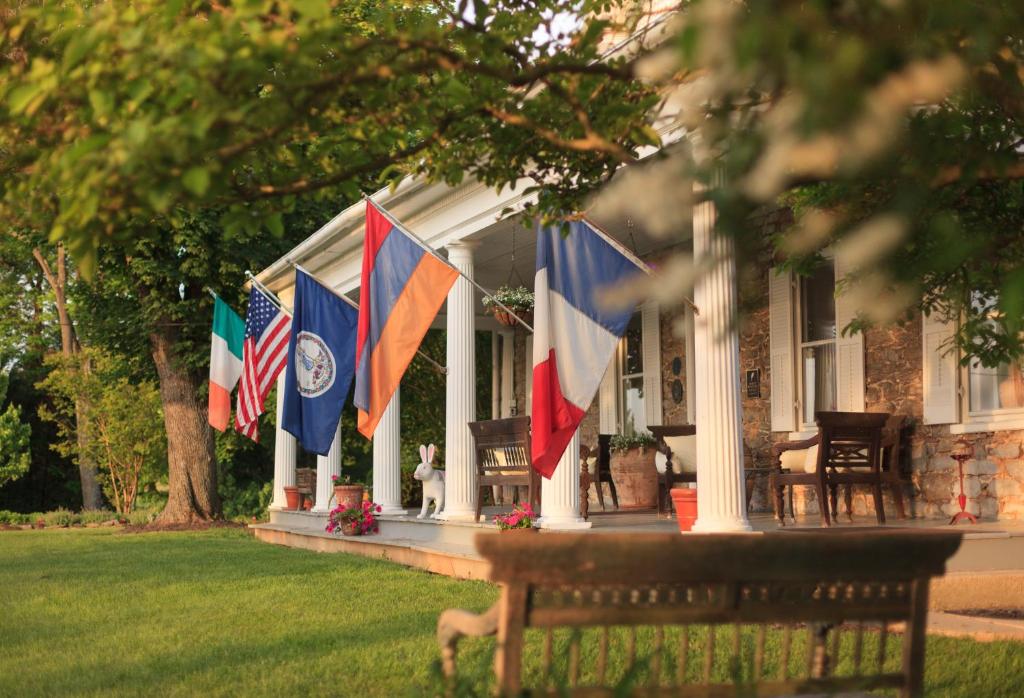 a group of flags on the front of a house at L'Auberge Provencale Inn & Restaurant in Boyce