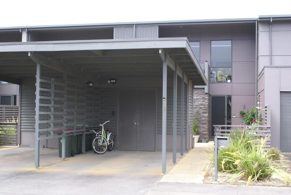 een fiets geparkeerd onder een gebouw met een garage bij Torquay Golf Retreats - Pool, Beach, Tennis, Golf in Torquay