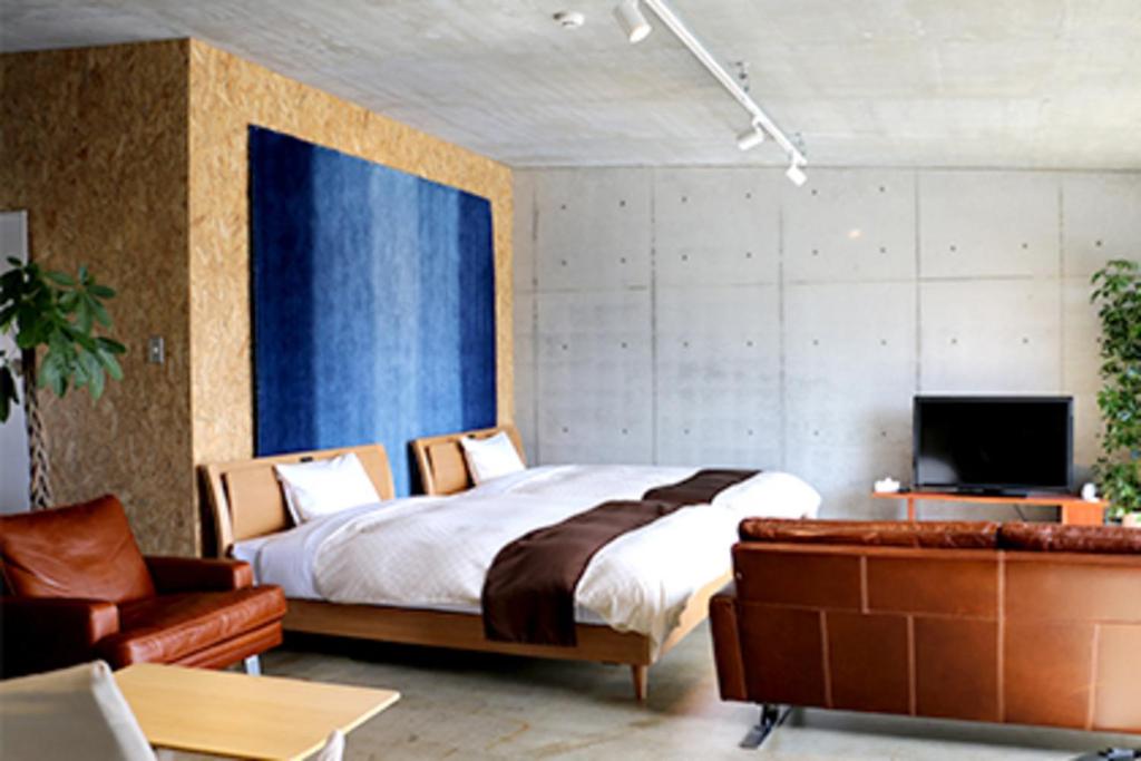 Yahabaにあるオガールインのベッドルーム(ベッド1台、ソファ、テレビ付)