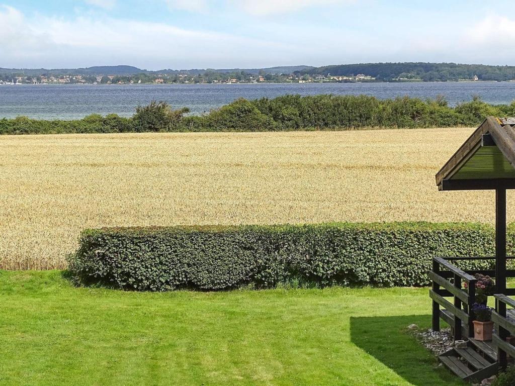 uma vista para um campo de relva e uma vedação em 8 person holiday home in Svendborg em Svendborg