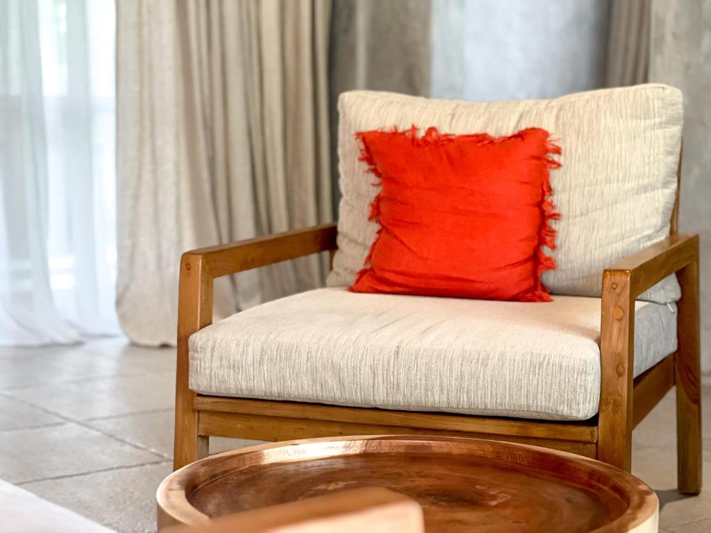 a red pillow sitting on a chair in a room at Diamond Beach Villas in Nusa Penida