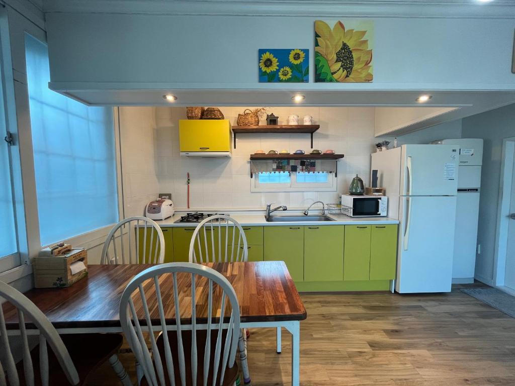 eine Küche mit einem Holztisch und einem Kühlschrank in der Unterkunft Artist and Flower Pension in Namhae