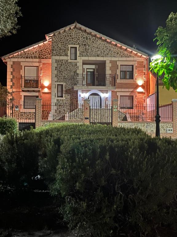 una gran casa de ladrillo con balcón por la noche en EL RECREO, en Mojados