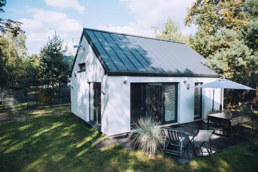 een tiny house met een patio en een tafel bij NAREV Domy Wakacyjne Pomiechówek Modlin Każdy Dom Ogrodzony in Pomiechówek