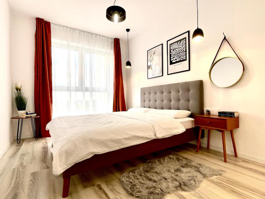 a bedroom with a large bed and a window at Sunset View Apartment in Timişoara