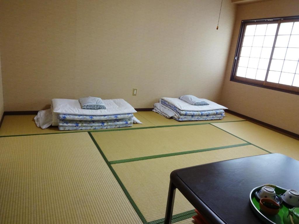 Postel nebo postele na pokoji v ubytování Imazato Ryokan