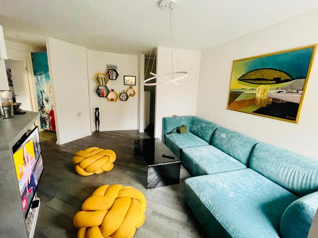 uma sala de estar com um sofá azul e uma televisão em Apartment next to the Wilson's Promenade em Sarajevo