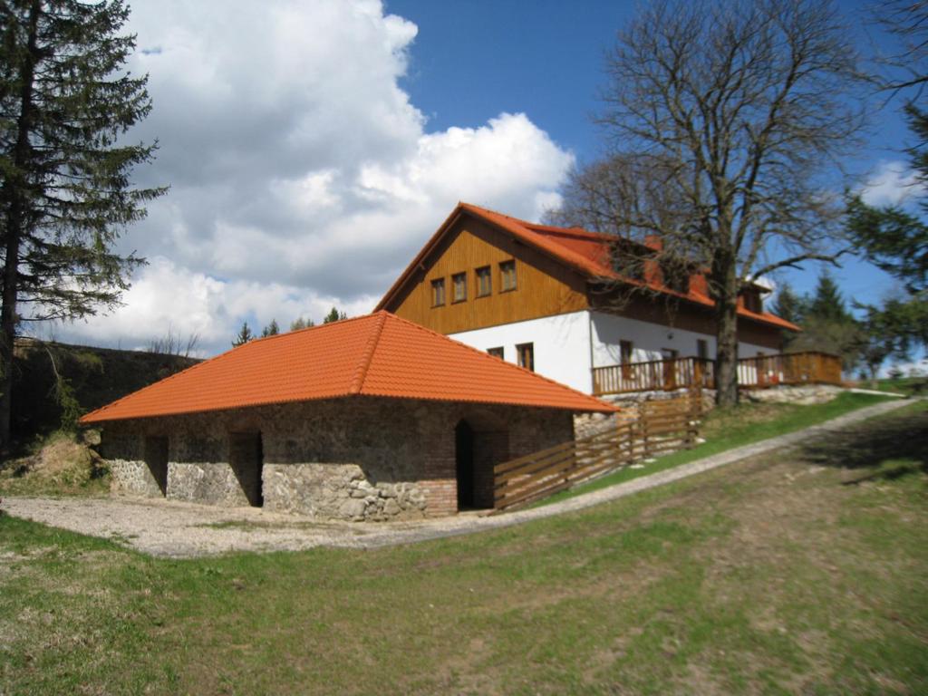 a large building with an orange roof on a field at Skalský Mlýn in Lísek