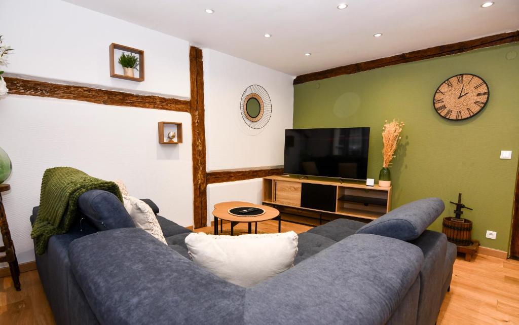 un salon avec un canapé bleu et une télévision dans l'établissement Au Duplex de Jeannala, à Sélestat