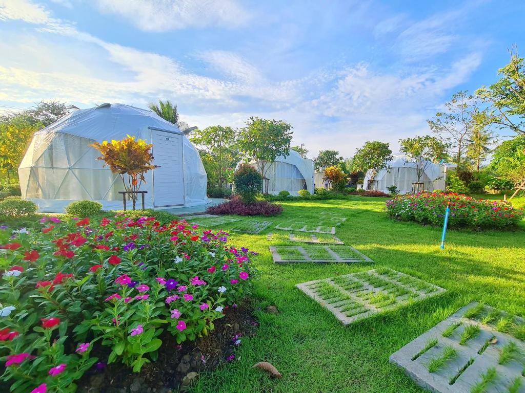 een tuin met een koepelkas en bloemen bij ปีกุนรีสอร์ท & Swimming pool (Pigoon Resort) 