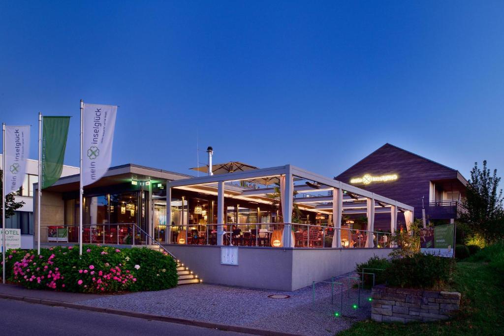 a building with a restaurant in the evening at Hotel mein inselglück in Reichenau