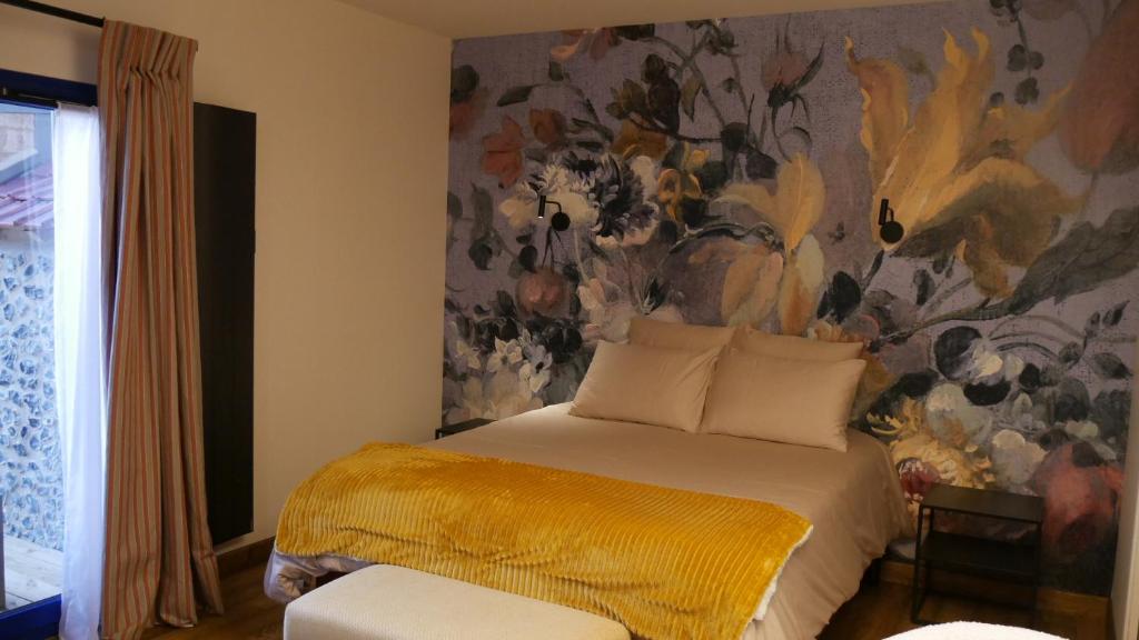1 dormitorio con 1 cama con una pintura en la pared en Maison HOUX en Dominois