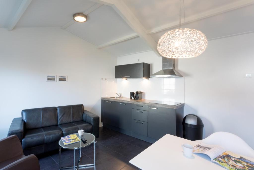 ein Wohnzimmer mit einem Sofa und einer Küche in der Unterkunft Hello Zeeland - Vakantiehuis Beatrixstraat 29A in Domburg