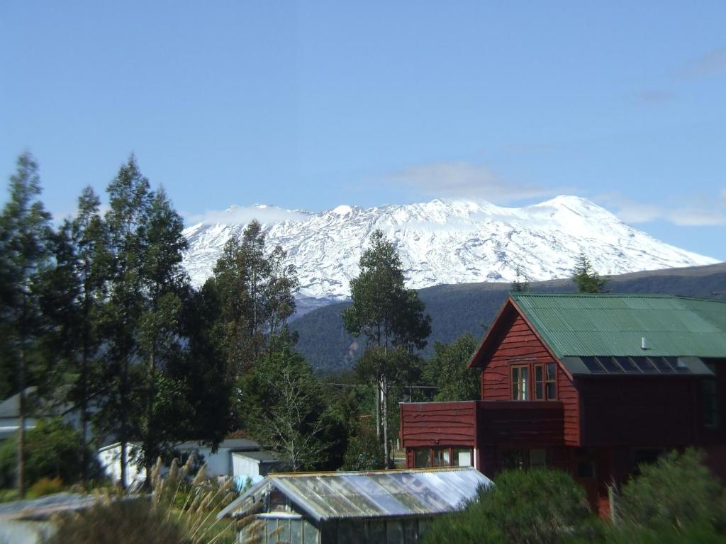a house with a snow covered mountain in the background at Mount Vista - National Park Holiday Home in National Park
