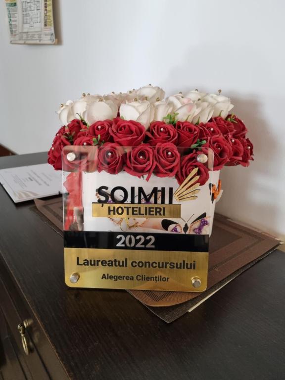 um ramo de rosas vermelhas numa caixa sobre uma mesa em Bicaz-Chei em Bicaz Chei