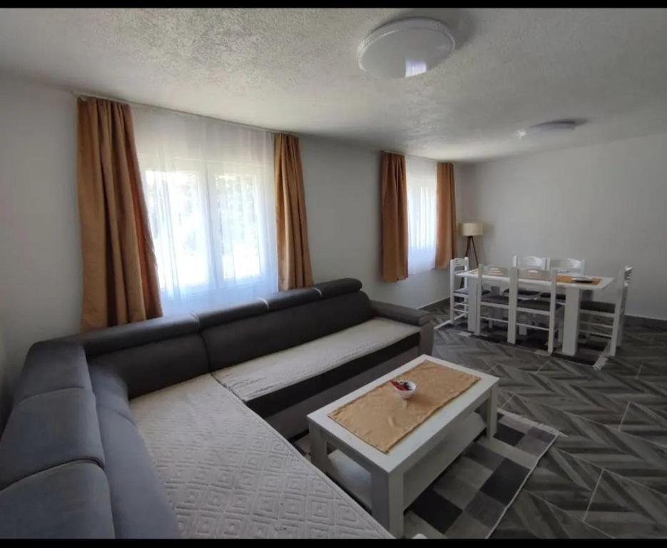 ein Wohnzimmer mit einem Sofa und einem Tisch in der Unterkunft House Bozovic in Žabljak