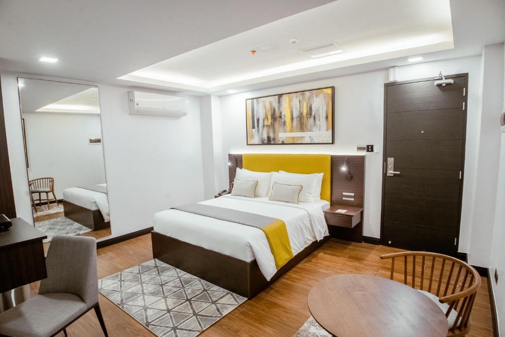 マニラにあるASN Boutique Residenceの大きなベッドと椅子が備わるホテルルームです。