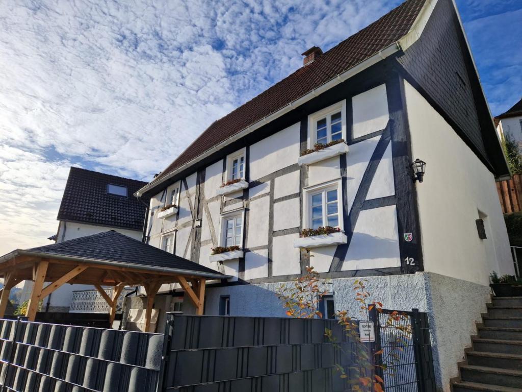 un gran edificio blanco y negro con cenador en ALTES ZOLLHAUS der Burg Hachen, 