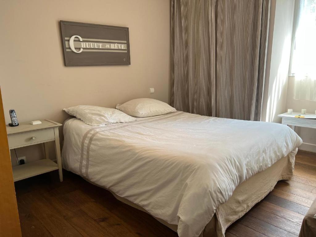 a bedroom with a white bed and a window at Chambres au calme chez l'habitant in Vertou