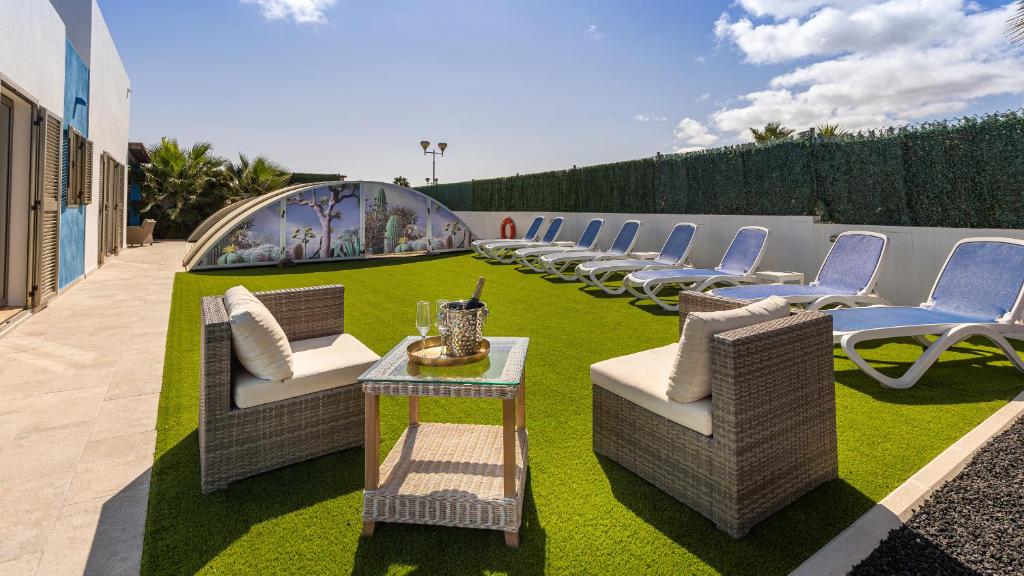 a row of chairs and tables on a lawn at Luxury Villa Melissa in Costa de Antigua