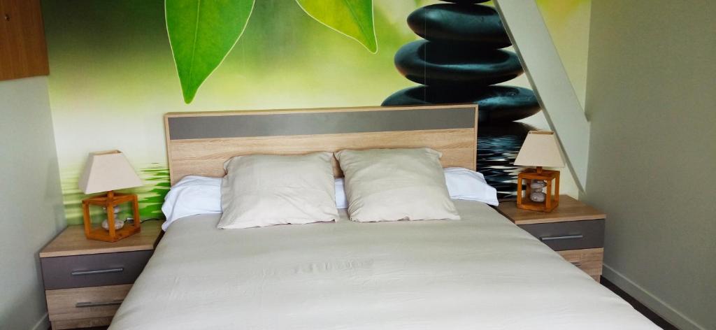 una camera con un letto con due cuscini e due lampade di AU NID DOUILLET DE LA FERME CHAUVET a Chantenay-Villedieu